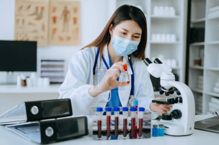 Photo for Young scientists conducting research investigations in a medical laboratory, a researcher in the foreground is using a microscope in laboratory for medicine. - Royalty Free Image