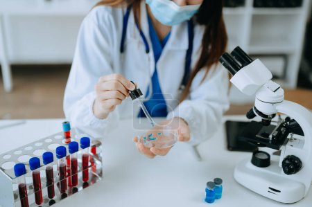 Photo for Female doctor working with microscope and test tubes in laboratory - Royalty Free Image
