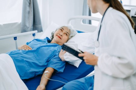 Téléchargez les photos : Médecin femme traitant le patient sur le lit avec une solution saline à l'hôpital ou à la clinique - en image libre de droit