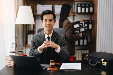 Téléchargez les photos : Un avocat asiatique travaillant avec un ordinateur portable dans un cabinet d'avocats. Concept de services juridiques et juridiques - en image libre de droit