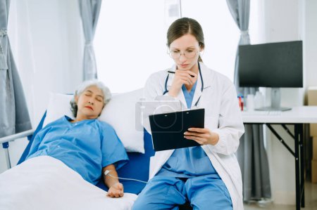 Foto de Médico y paciente discutiendo algo mientras está en la cama de examen en la clínica moderna o el hospital. Concepto de medicina y salud - Imagen libre de derechos