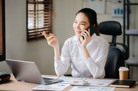 Photo for Business asian woman Talking on the phone while sitting at modern office - Royalty Free Image