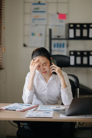 Téléchargez les photos : Asiatique femme d'affaires stressé et ennuyé après une longue journée au bureau. - en image libre de droit