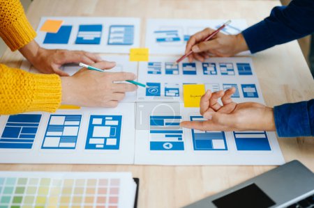 Photo for UX developer and ui designer brainstorming about mobile app interface wireframe design with customer brief and color code at modern office - Royalty Free Image