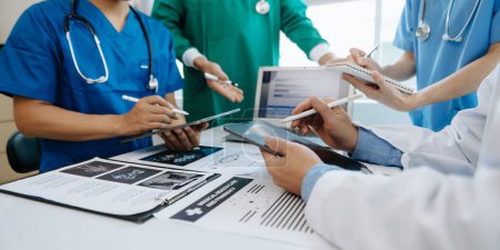 Photo for Medical team having a meeting seated at a table and discussing a patients, working online and using computers in the medical industry or hospital - Royalty Free Image