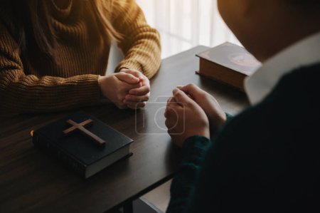 Téléchargez les photos : Deux personnes lisant la Bible à la maison et priant ensemble. Étudier la Parole de Dieu avec des amis - en image libre de droit