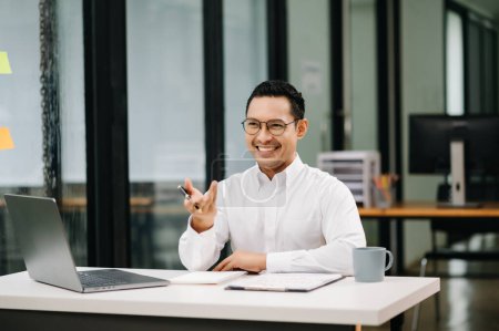 Foto de Confiado empresario asiático con una sonrisa en la oficina moderna - Imagen libre de derechos
