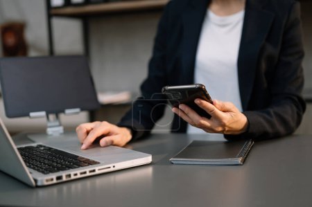 Téléchargez les photos : Femme d'affaires travaillant avec smartphone et ordinateur portable - en image libre de droit