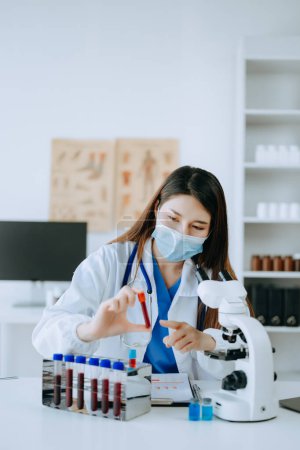 Photo for Young scientist conducting research in medical laboratory, female researcher working with test tubes - Royalty Free Image