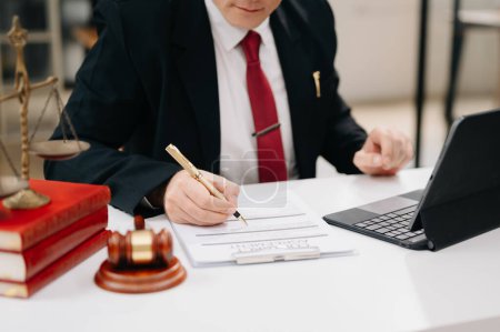 Photo for Justice and law concept. Male judge in a courtroom the gavel, working with digital tablet computer on white table - Royalty Free Image
