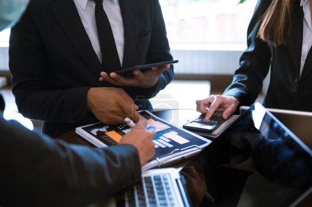 Téléchargez les photos : Réunion de l'équipe d'affaires avec un investisseur professionnel travaillant avec tablette numérique et ordinateur portable - en image libre de droit