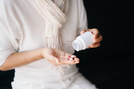 Photo for Old woman with bottle pills on hand going to take medicaments prescribed by his physician at home - Royalty Free Image