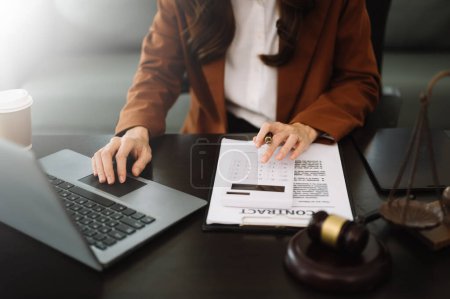 Téléchargez les photos : Justice et concept de droit. femme d'affaires travaillant sur des comptes à l'aide d'un ordinateur portable dans un bureau moderne - en image libre de droit