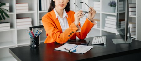 Téléchargez les photos : Jeune attrayant asiatique femme de bureau costume d'entreprise de travail avec ordinateur dans le bureau moderne - en image libre de droit