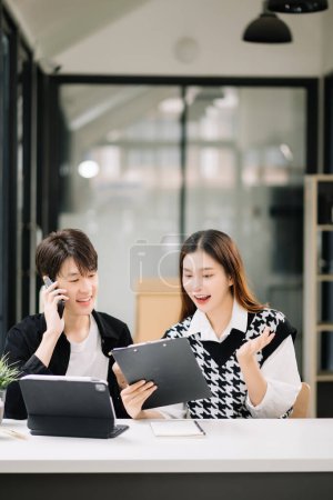 Photo for Two Asian business workers using tablet at the home office - Royalty Free Image