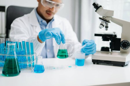 Photo for Scientist mixing liquids in chemical lab. Researcher working with test tubes - Royalty Free Image