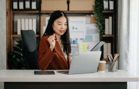 Téléchargez les photos : Femme d'affaires asiatique travaillant avec tablette pc et des documents pour ordinateur portable dans le bureau moderne - en image libre de droit