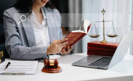 Foto de Una abogada leyendo un libro legal con mazo en la mesa en la oficina. justicia y derecho - Imagen libre de derechos