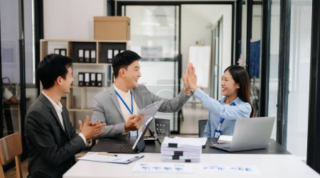 Photo for Group of Young Asian business team celebrating achievement and in planning design in creative in modern office - Royalty Free Image