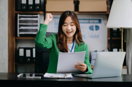 Téléchargez les photos : Femme d'affaires asiatique sont ravis et heureux de célébrer la réalisation avec le travail qu'ils font sur ordinateur portable au bureau. - en image libre de droit