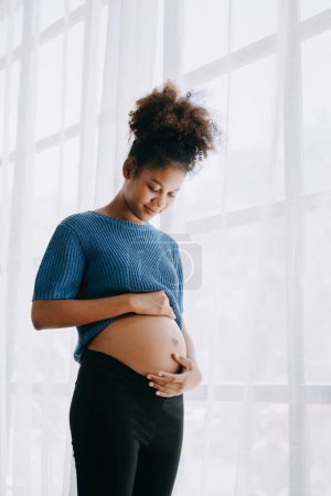 Photo for Pregnant african american woman at home window white background space - Royalty Free Image