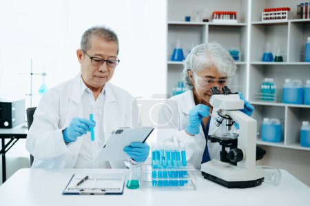 Foto de Dos científicos asiáticos se reúnen y analizan los resultados en el laboratorio - Imagen libre de derechos