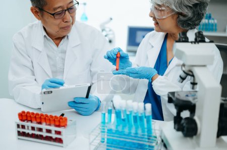 Foto de Dos científicos asiáticos se reúnen y analizan los resultados en el laboratorio - Imagen libre de derechos