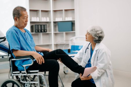 Photo for Asian physiotherapist helping elderly man patient stretching leg in hospital - Royalty Free Image