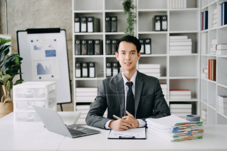 Foto de Joven hombre de negocios gerente ejecutivo utilizando el ordenador portátil, haciendo investigación de mercado y trabajando en la oficina moderna - Imagen libre de derechos