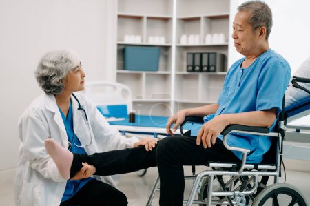 Photo for Asian physiotherapist helping elderly man patient stretching leg in hospital - Royalty Free Image