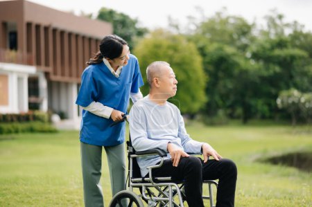 Photo for Elderly asian senior man on wheelchair with Asian careful caregiver. Nursing in hospital garden - Royalty Free Image
