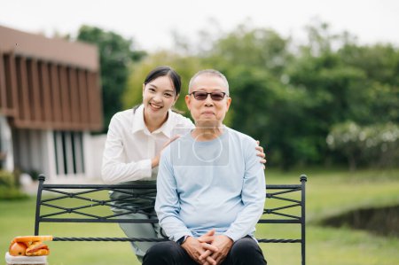 Photo for Happy adult granddaughter and senior grandfather sitting outdoor in the park - Royalty Free Image