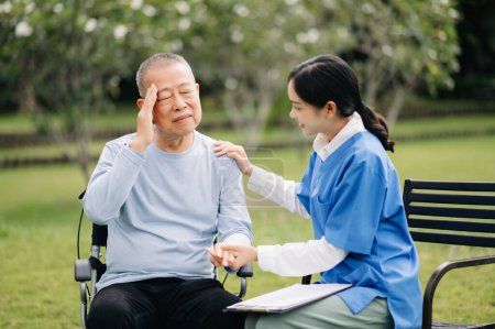 Téléchargez les photos : Aîné asiatique homme âgé en fauteuil roulant avec soignant asiatique soignant. Maison de soins infirmiers hôpital jardin - en image libre de droit