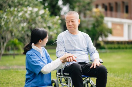 Photo for Elderly asian senior man on wheelchair with Asian careful caregiver. Nursing home hospital garden - Royalty Free Image