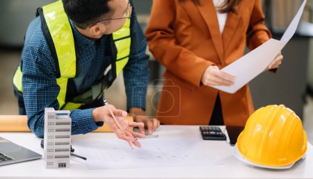 Photo for Two colleagues discussing data, working on architectural project at construction office - Royalty Free Image