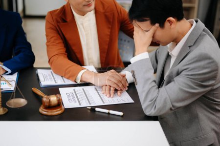 Téléchargez les photos : Asiatique gens d'affaires compatissant tenant la main et discuter des documents contractuels dans la salle de bureau - en image libre de droit