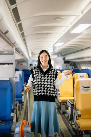 Téléchargez les photos : Attrayant asiatique passager féminin de l'avion assis dans un siège confortable. Voyage dans le style - en image libre de droit
