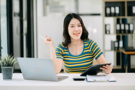 Téléchargez les photos : Femme asiatique confiante avec un sourire travaillant au bureau à domicile - en image libre de droit