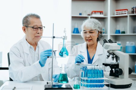 Téléchargez les photos : Réunion de deux scientifiques asiatiques principaux et analyse des résultats en laboratoire - en image libre de droit