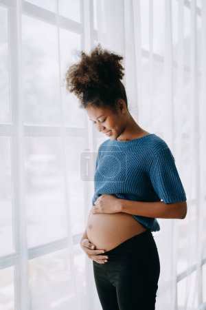 Photo for Pregnant african american woman at home window white background - Royalty Free Image