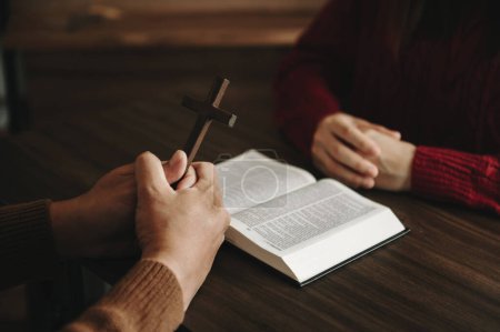 Photo for Two people reading and study bible in home and pray together. Studying the Word Of God With Friends - Royalty Free Image