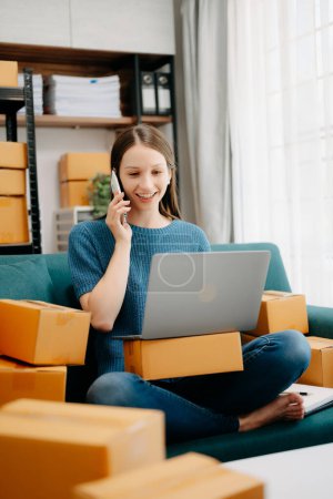 Photo for Startup small business SME, Entrepreneur owner woman taking receive and checking online purchase shopping order to preparing pack product boxes - Royalty Free Image