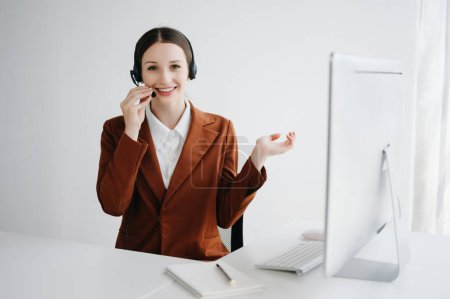 Photo for Serious call center operator in wireless headset talking with customer in customer support service in business center - Royalty Free Image