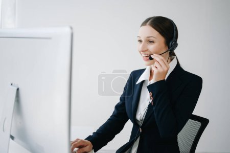 Téléchargez les photos : Opérateur de centre d'appels sérieux dans casque sans fil parler avec le client dans le service d'assistance à la clientèle dans le centre d'affaires - en image libre de droit