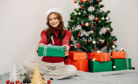 Photo for Woman Watch at Christmas Present. Portrait of Young female. Preparations for Celebration.Happiness at Home. Holiday Concept.Decorating Christmas Tree - Royalty Free Image