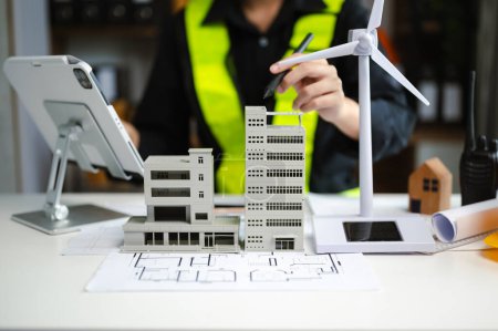 Foto de Primer plano de la empresaria en el sitio del proyecto arquitectónico y fabricación de casa modelo sobre energía eólica en la oficina de la empresa - Imagen libre de derechos