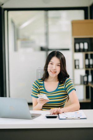 Téléchargez les photos : Femme asiatique confiante avec un sourire travaillant au bureau à domicile - en image libre de droit