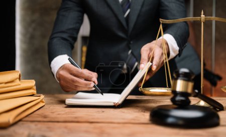 Photo for Business lawyer discussing contract papers with brass scale on desk in office. Law, legal services, advice,  justice and law concept in office - Royalty Free Image
