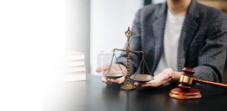 Photo for Male lawyer in the modern office with brass scale on wooden table. justice and law concept in morning light - Royalty Free Image