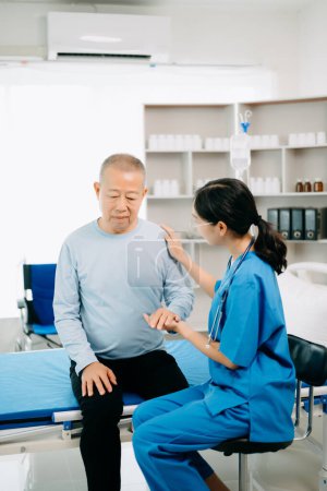 Foto de Médico asiático hablando con paciente mayor y recibiendo solución salina en hospital o clínica. - Imagen libre de derechos